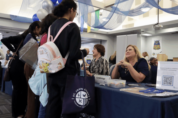 Students and healthcare worker at expo vendor table